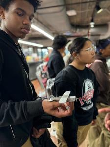 Student holds example of medal fabrication of model plane